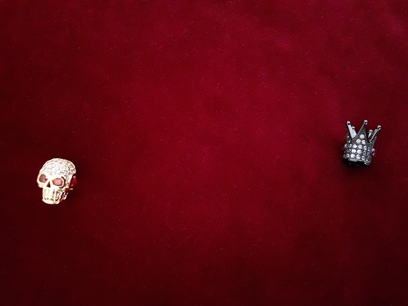biżuteryjne czaszki i korony na ozdobnej poduszce